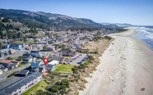 Coastal town property nestled between forested mountains and pristine Pacific coastline with expansive sandy beaches.