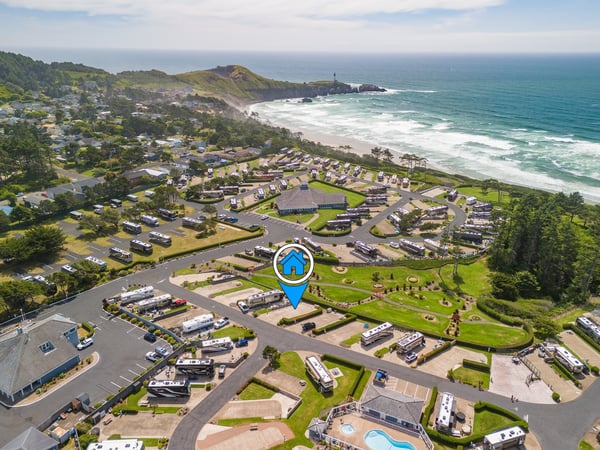 Coastal RV resort featuring multiple sites with direct beach access, landscaped grounds, and stunning ocean views along the scenic shoreline with nearby lighthouse.