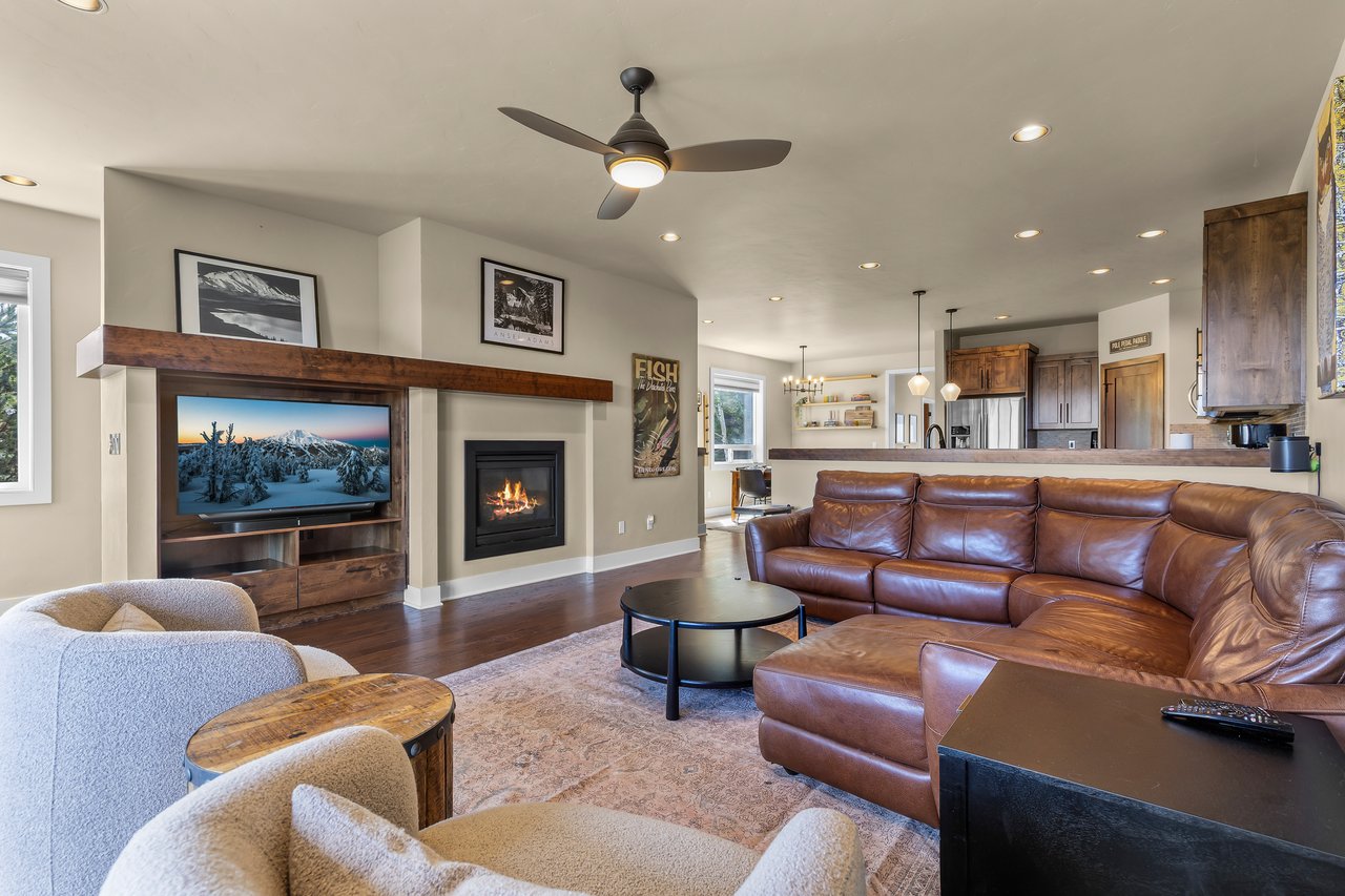Unwind in your spacious living room, where a crackling fireplace and plush leather seating create the perfect retreat after a day of mountain adventures.