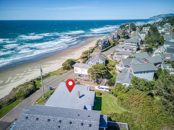 Coastal community with oceanfront homes positioned directly on the sandy beach with rolling waves and scenic shoreline.