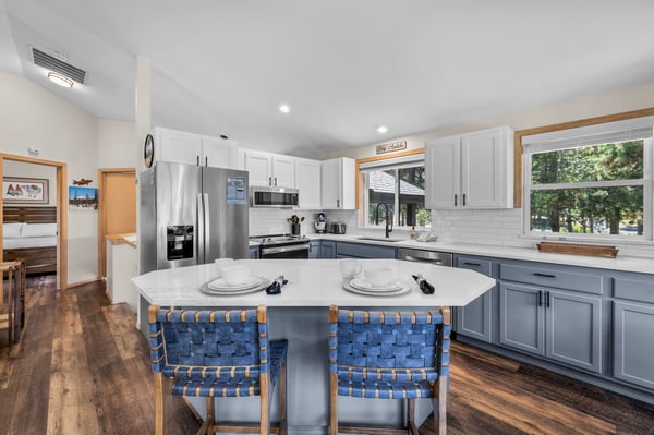 Your spacious kitchen invites you to gather and create, with a large island and natural light streaming through the windows overlooking the trees outside.