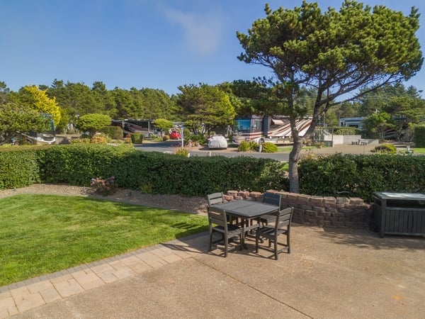 Your private outdoor patio invites relaxed mornings and starlit evenings, with lush green lawns and mature shade trees creating a peaceful retreat right outside your door.
