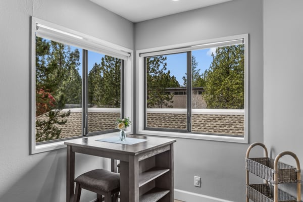 Natural light pours through bright windows overlooking peaceful treetops, creating your perfect morning retreat for coffee and quiet moments.