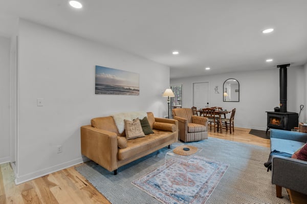 Sink into the cozy leather sofa or curl up by the fireplace in this bright, open living space—perfect for relaxing after a day of exploring.