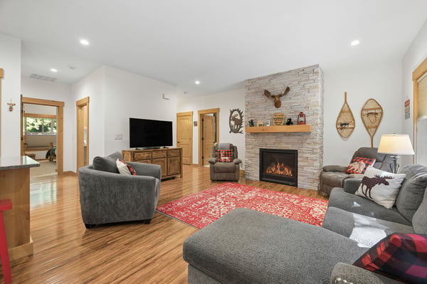 Gather around the glowing fireplace surrounded by plush seating and rustic charm, where warm wood tones and cozy textures invite you to unwind after your mountain adventures.