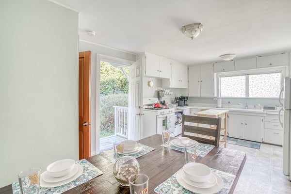 Gather around this sun-filled kitchen where your morning coffee tastes better and dinner conversations flow naturally at the farmhouse table.