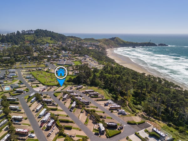 Coastal property nestled between forested hills and pristine beach, offering easy access to ocean waves and scenic clifftop trails.