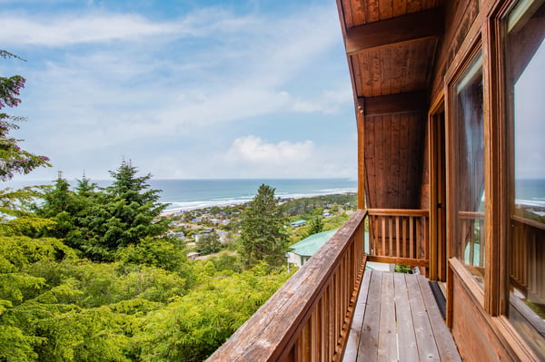 Elevated coastal retreat offering sweeping views of the shoreline and surrounding community from this charming wooden balcony. A peaceful hillside location surrounded by lush trees and ocean breezes.