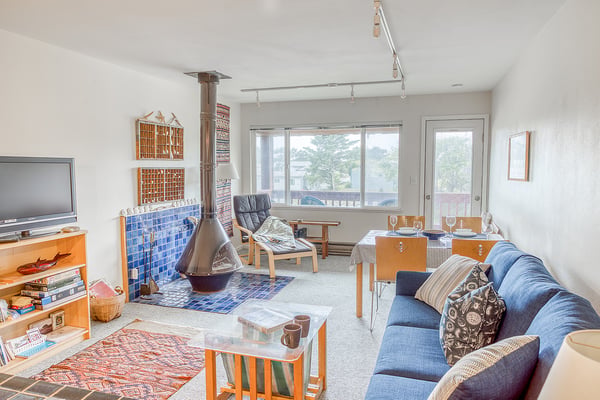 Unwind in this cozy living and dining space, where your vacation unfolds beside a charming fireplace. Natural light pours in from large windows, while the open layout invites relaxation and memorable meals together.