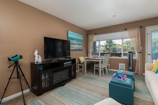 Your bright, open-plan retreat features a dining nook framed by soft natural light and a cozy entertainment setup. Unwind after a day of exploring, with everything you need close at hand.