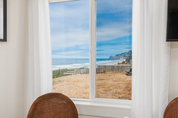 Picture yourself settling in at the table, gazing through the window at shimmering waves and coastal cliffs framing your perfect oceanfront escape.