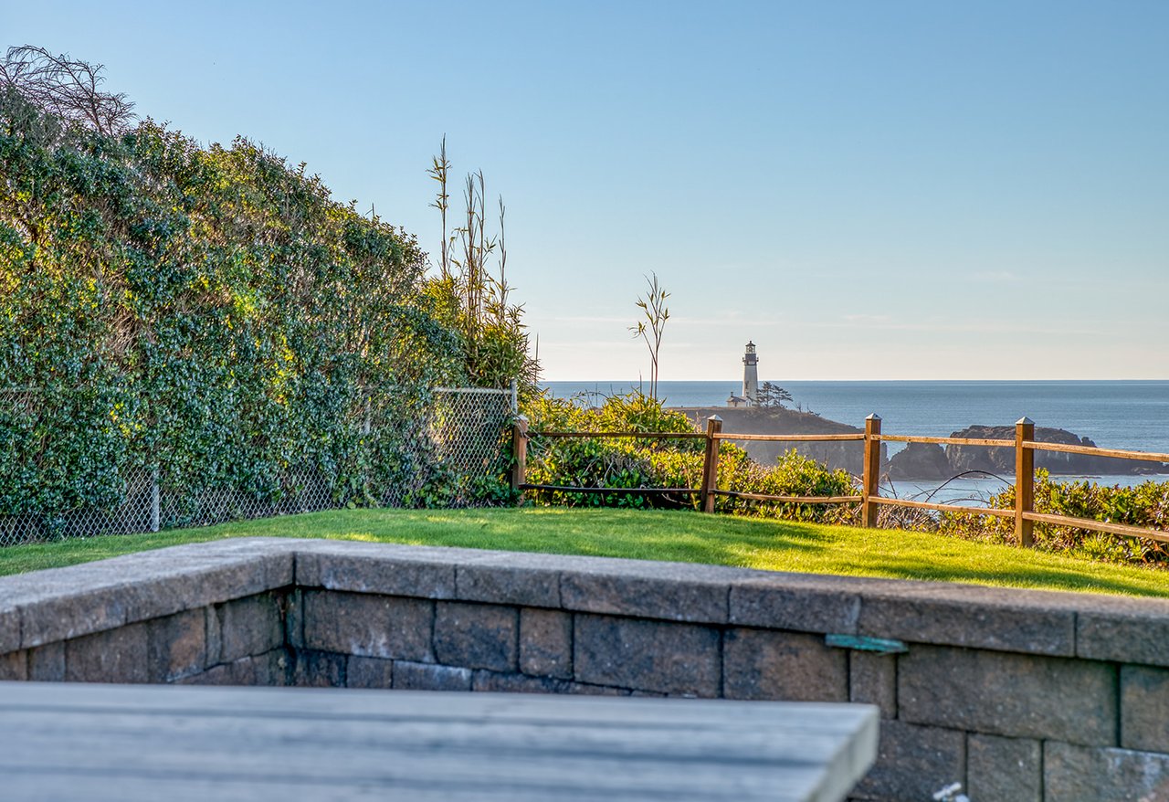 Coastal property featuring landscaped gardens and dramatic lighthouse views across the ocean horizon.