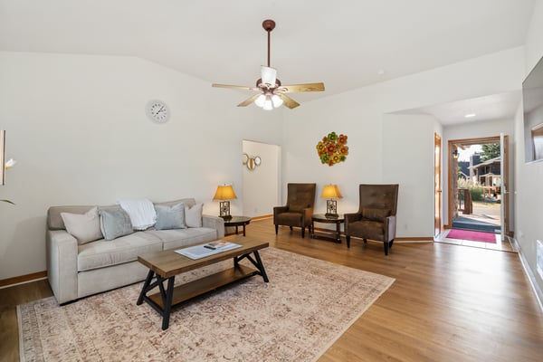 Relax in your spacious, light-filled living room with comfortable seating and warm wood floors that welcome you home.
