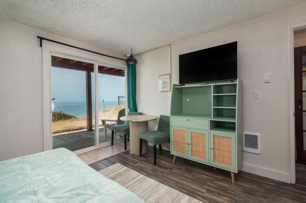 Wake up to the ocean just steps from your door. Slide open the glass and step onto your private patio, where the coastline stretches out before you in soft morning light.
