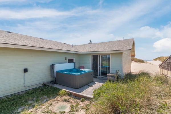 Beachside retreat featuring a private hot tub and direct dune access, perfect for soaking under coastal skies.