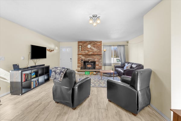 Cozy up in your spacious living room with leather seating arranged around a warm brick fireplace, perfect for movie nights.