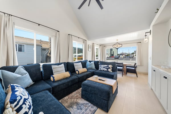 Sink into the plush sectional and feel instantly at home in this light-filled living space, where soaring ceilings and ocean breezes create your perfect coastal retreat.