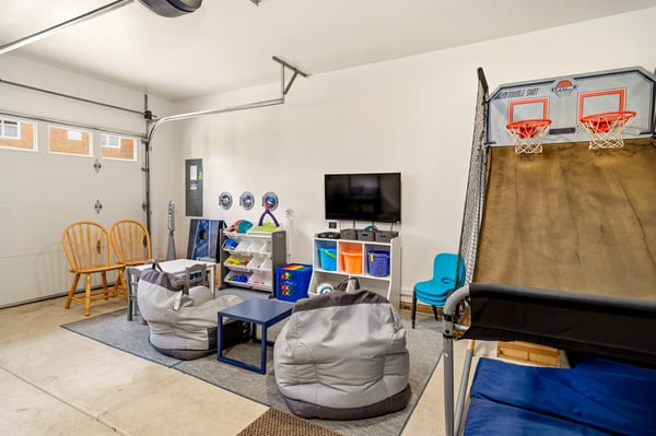 Your kids will love this fun-filled game room with basketball hoops, cozy bean bags, and a TV for movie nights—perfect for family entertainment.
