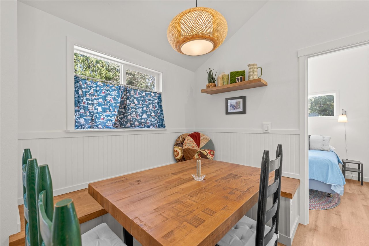 Gather around this charming dining table where natural light streams in through cheerful windows, creating the perfect spot for your morning coffee.