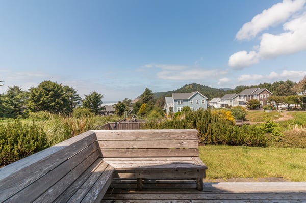 A peaceful coastal neighborhood surrounded by lush greenery and distant mountains, offering a serene backdrop for your stay.