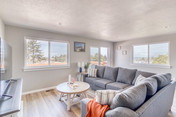 Sink into plush seating and enjoy stunning coastal views through expansive windows. Your perfect retreat features modern comfort and natural light framing the ocean horizon.
