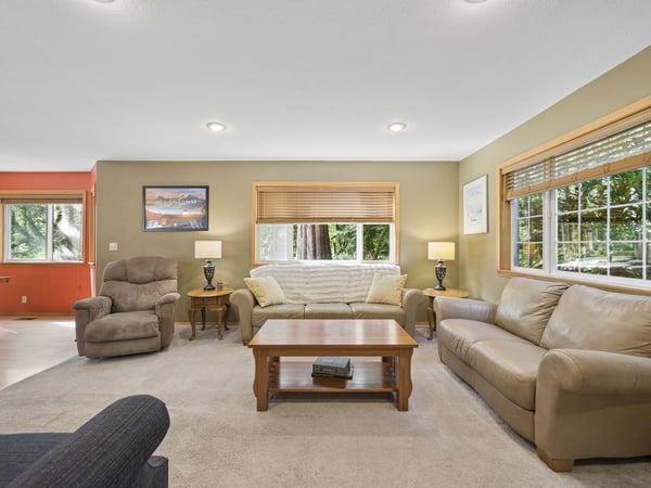 Sink into your favorite seat in this welcoming living room, where natural light and comfortable furnishings create the perfect space to unwind together.