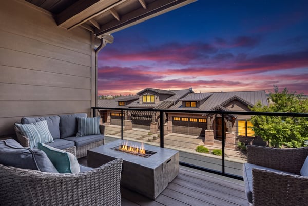 The main property illuminated under a vibrant sunset sky, with visible residential structures and surrounding neighborhood context during dusk hours.