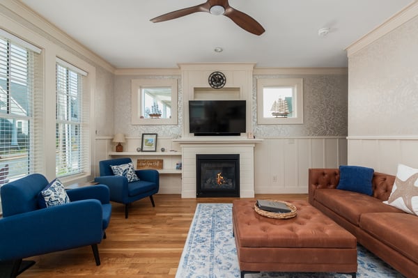 Relax in your stylish living room featuring plush seating, a cozy fireplace, and elegant coastal décor for perfect evenings together.