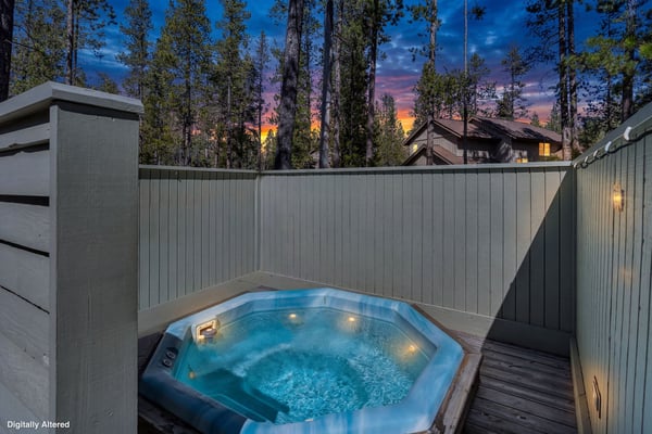 A private hot tub surrounded by towering pines offers magical sunset views in this secluded forest retreat.