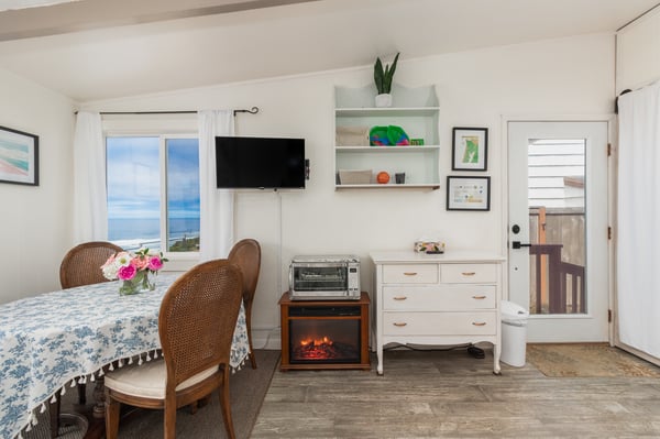 Picture yourself relaxing at the cozy dining table with fresh flowers as the ocean stretches across the horizon through your window—a peaceful retreat where every meal comes with a view.