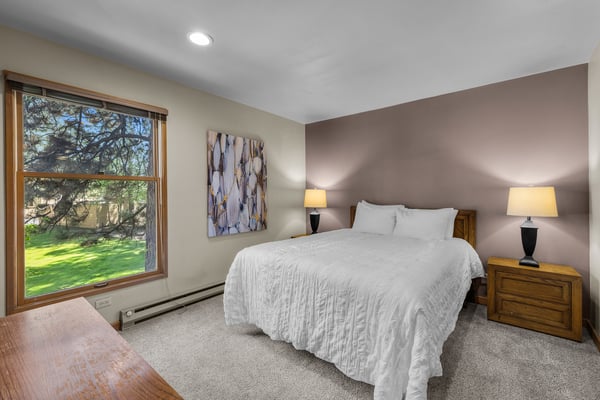 Slip into crisp linens and wake to garden views framing your serene bedroom retreat, where warm wood tones and soft lighting create your peaceful escape.