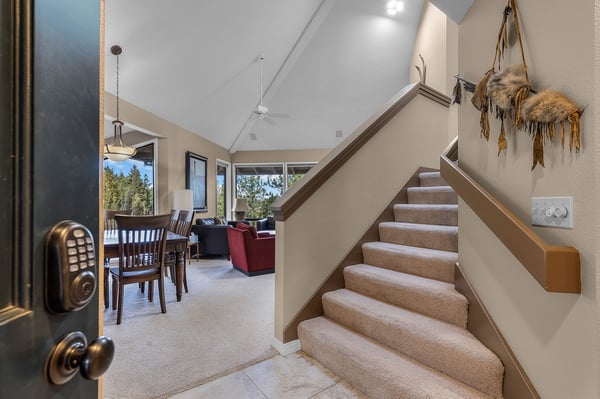 Step into your spacious retreat where vaulted ceilings and warm carpeted stairs lead to comfortable living spaces with mountain views.