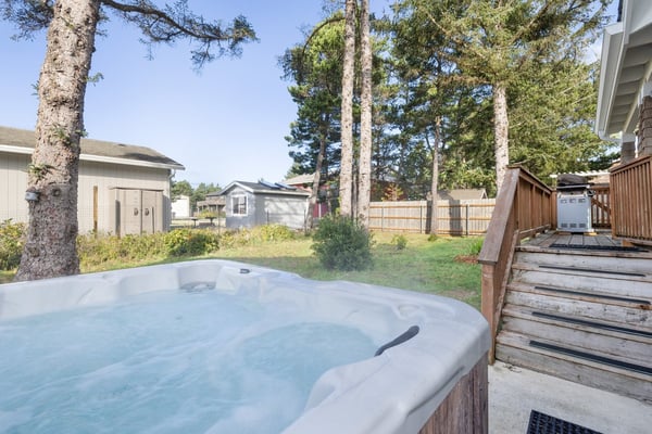 Soak away your worries in this private hot tub, surrounded by peaceful trees and open sky for the ultimate relaxation experience.