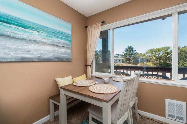 Your sunny breakfast nook welcomes morning light through large windows overlooking trees and neighboring rooftops. The cozy table for four is perfect for leisurely meals or game nights.