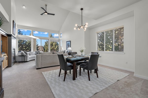 Relax in your bright open-plan living space with vaulted ceilings, modern furnishings, and large windows flooding the room with natural light.