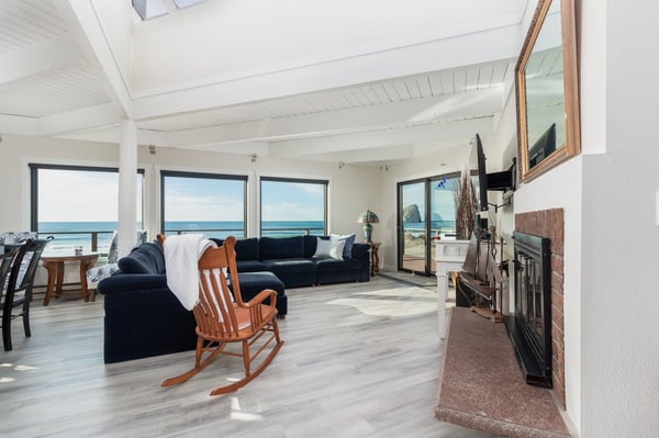 Unwind in your oceanfront living room where waves meet comfort - cozy fireplace, panoramic windows, and endless sea views create your perfect coastal retreat.