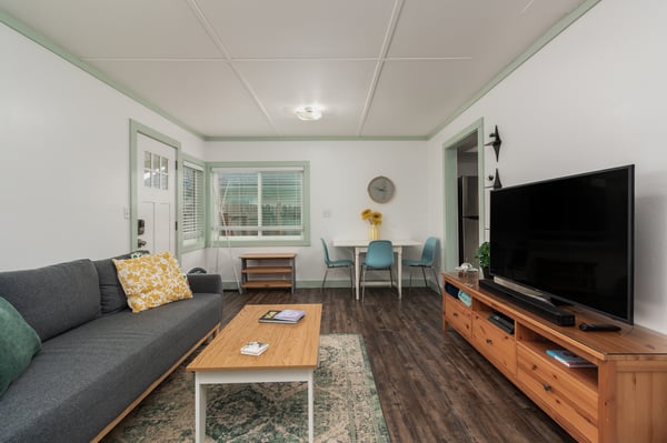 Relax in your spacious living area with comfortable seating, large TV, and cheerful pops of color throughout.