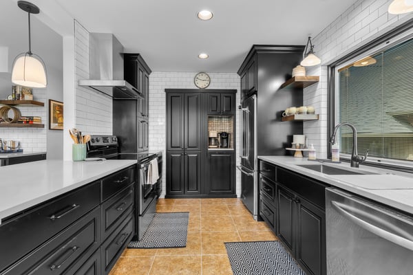 Step into your fully equipped chef's kitchen with sleek black cabinetry, white subway tile, and marble countertops. Everything you need to create memorable meals in style.