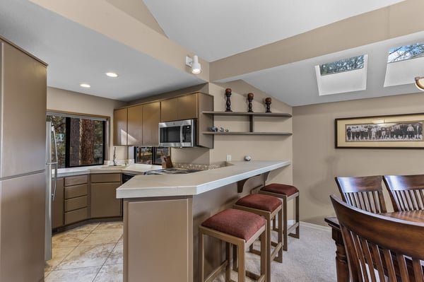Your spacious kitchen welcomes you with sleek countertops, modern appliances, and a breakfast bar perfect for morning coffee under natural skylights.