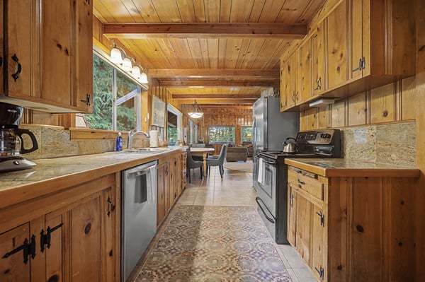 Your rustic cabin kitchen features warm wood cabinets, granite counters, and modern appliances for memorable meals.