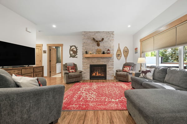 Gather around the glowing fireplace with friends and family in this spacious living room, where rustic charm meets modern comfort and plush seating invites you to relax after a day of adventure.