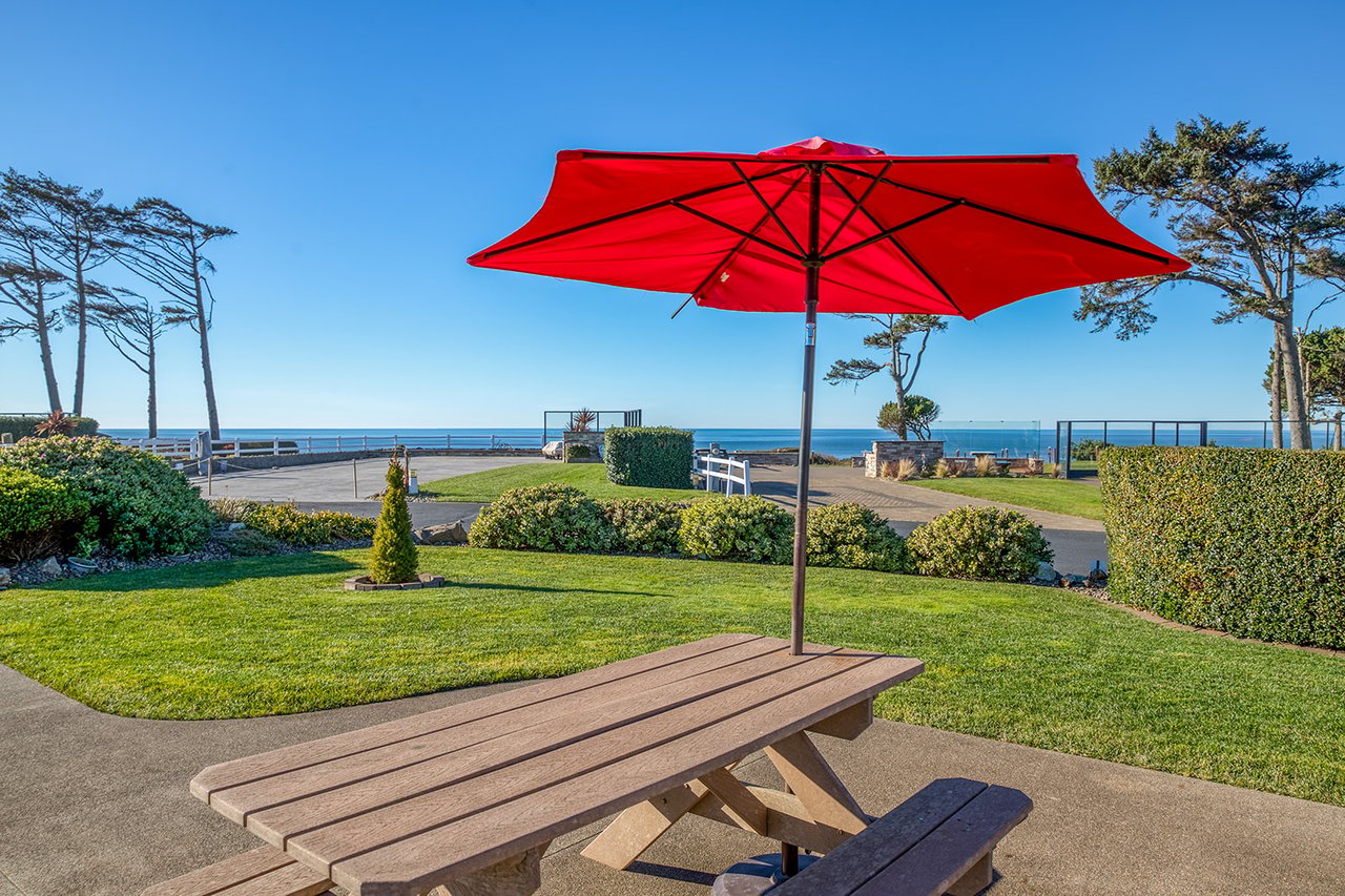 Relax at your private picnic table with ocean views, where coastal breezes and the red umbrella create the perfect spot for meals.