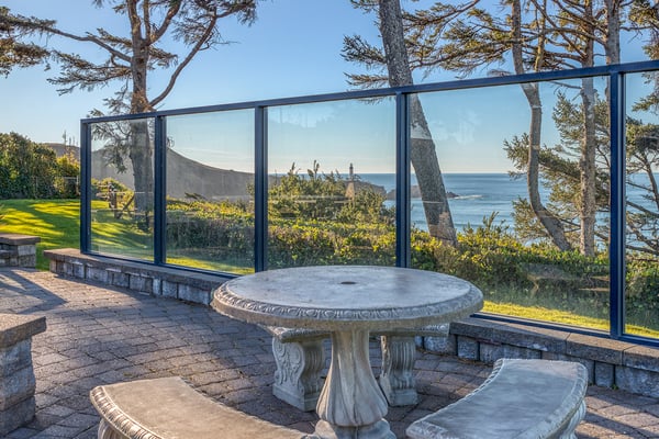 Your private oceanfront terrace features stunning sea views through native cypress trees, perfect for morning coffee or sunset dining.