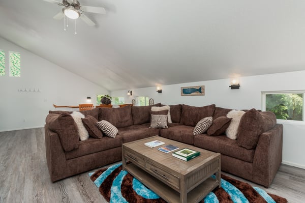 Sink into plush sectional seating in your bright, open living space where comfort meets style. Large windows invite natural light to fill the room, perfect for relaxed evenings together.