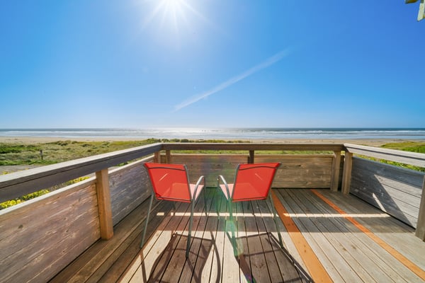 Private oceanfront deck with two chairs facing pristine sandy beach and endless waves. Perfect spot to soak in sun, sea breeze, and coastal tranquility throughout your stay.