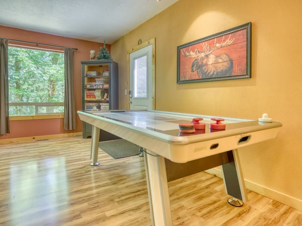 Challenge your group to a friendly game of air hockey in this bright, woodland-view game room—perfect for downtime and laughter between adventures.