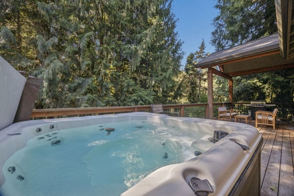 Slip into the bubbling hot tub on your private deck, where towering evergreens frame blue skies and total relaxation awaits.