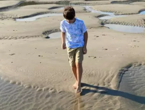 Boy beachcombing in Yachats, Oregon