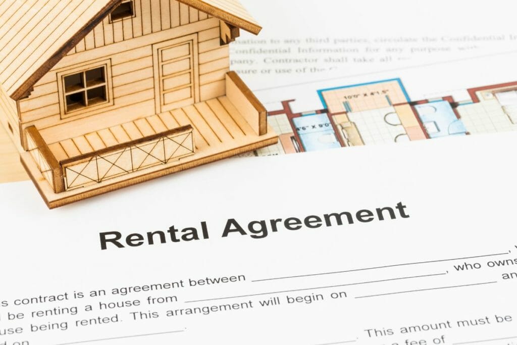 Blueprint of a home and rental agreement on a table. How to Make Money on a Vacation Rental Property - What to Know Before Making the Investment