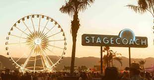Stagecoach entrance sign with ferris wheel and palm trees in background